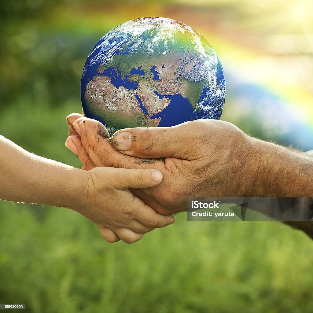 Earth Senior man and baby holding the Earth in hands against a rainbow in spring. Earth maps from: shadedrelief.com Licencing: shadedrelief.com/natural2/pages/use.html Globe - Navigational Equipment Stock Photo