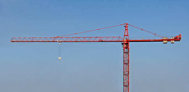 red crane against blue sky stock photo
