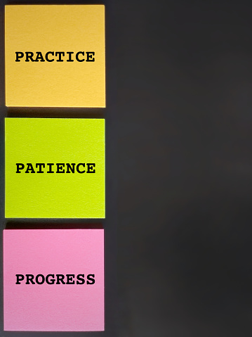 Inspirational Quote - practice patience progress text on multicolor paper background. Stock photo.