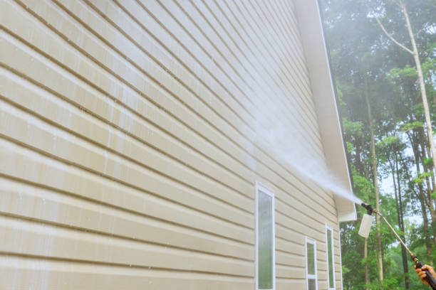 istock Service worker utilizes high pressure nozzles to efficiently clean siding houses with a water soap cleaner. 1559242236