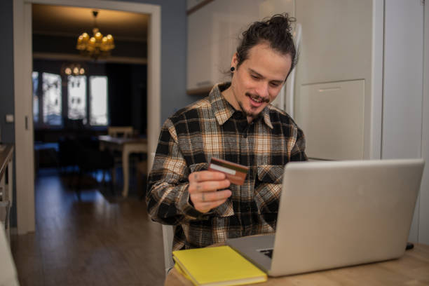istock Cheerful man doing online shopping 1559293081