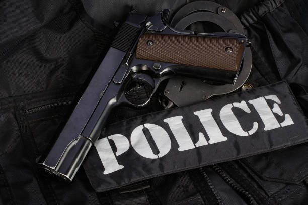 istock Police handgun with handcuffs on black uniform 1559318570