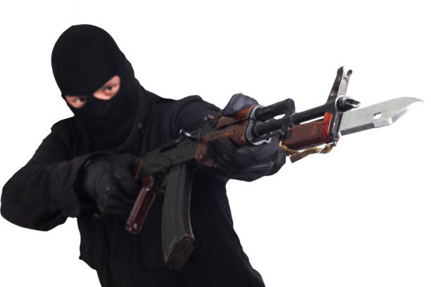 Sniper with beard in black holding gun. Studio shot.