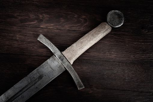 Medieval vintage sword on wooden backgrond.