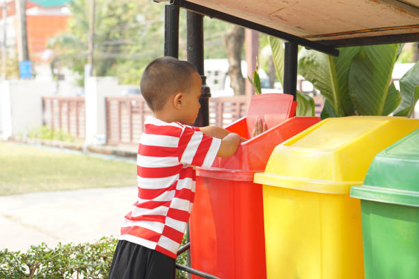 istock Boy looking at trash cans in the garden 1559385698