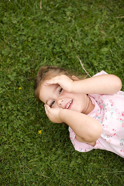 istock little girl lying on the grass 155938926