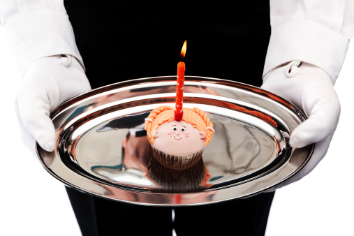 butler holding cupcake with candle
