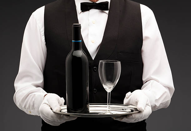 istock A waiter holding a small plate and a glass and wine bottle 155940273