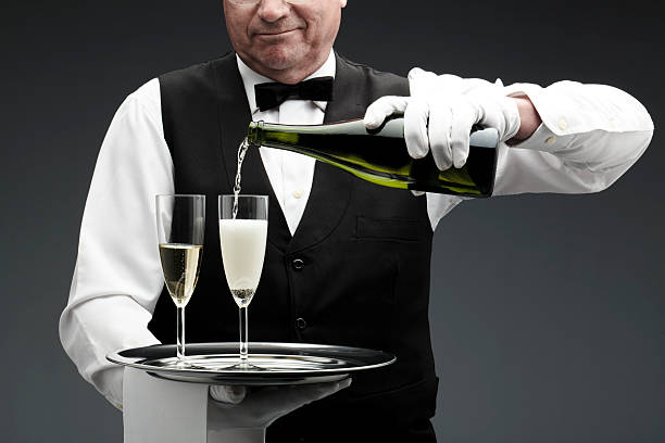 バトラーがシャンペングラスに注ぐ - butler champagne service waiter ストックフォトと画像