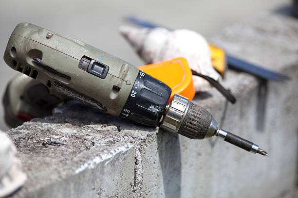 istock Workmans Cordless Electric Drill Outside On Wall 155946393