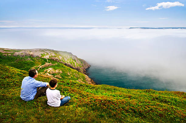 Father and son at foggy ocean coast Father and son looking at foggy ocean view in Newfoundland st. johns newfoundland photos stock pictures, royalty-free photos & images