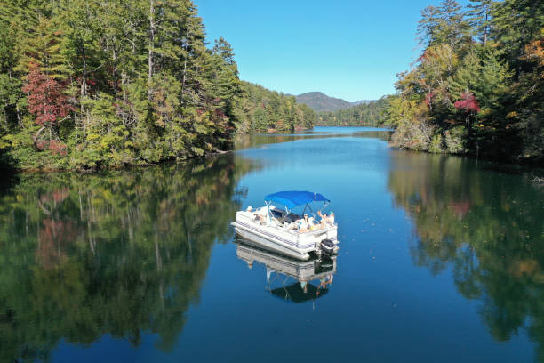 Aerial view of pontoon boat on Lake Santeetlah, North Carolina Aerial view of pontoon boat on Lake Santeetlah, North Carolina in autumn. pontoon boat stock pictures, royalty-free photos & images