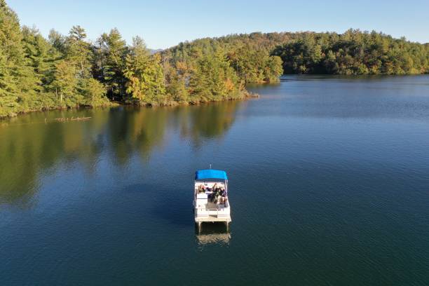 Aerial view of pontoon boat on Lake Santeetlah, North Carolina Aerial view of pontoon boat on Lake Santeetlah, North Carolina in autumn. pontoon boat stock pictures, royalty-free photos & images