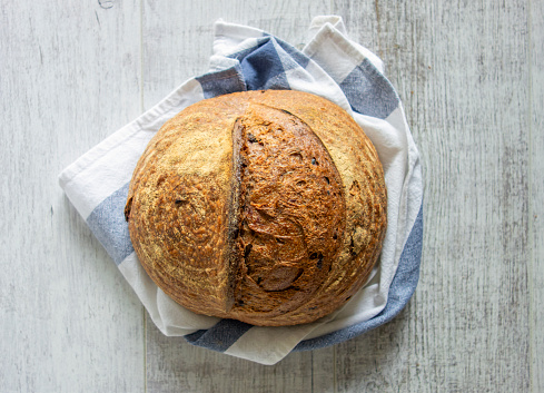 Looking down on a freshly baked loaf of organic bread on wooden table