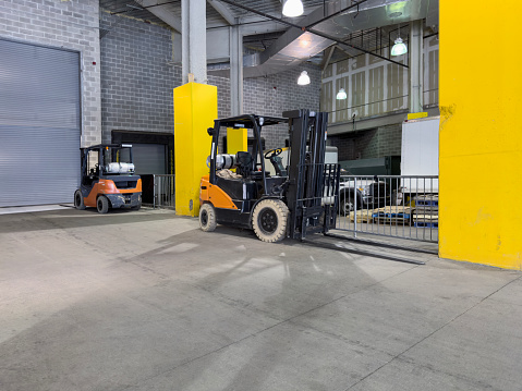 Forklifts on a loading dock in a factory building