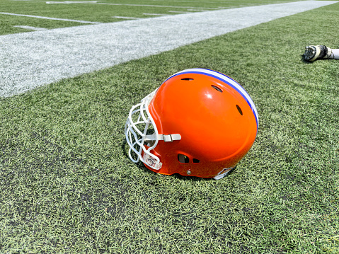 American football helmet in a practice field on a summer day