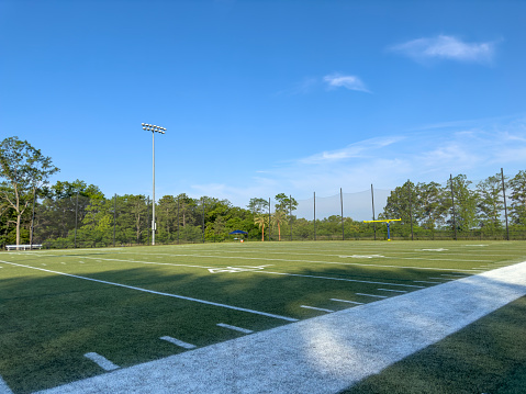 Wide angle view of an empty American football practice field on a summer day