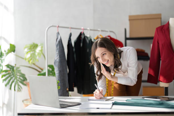istock female design at work in her studio with working in office calling to client by smartphone 1559509017
