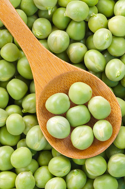 istock Fresh grren peas on wooden spoon 155952413