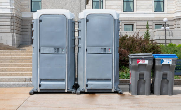 Portable mobile toilets and trash for recycle in the park. A line of chemical WC cabins for a festival event. stock photo