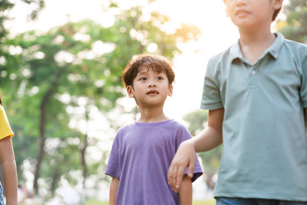 istock cute asian boy portrait in the park 1559543598