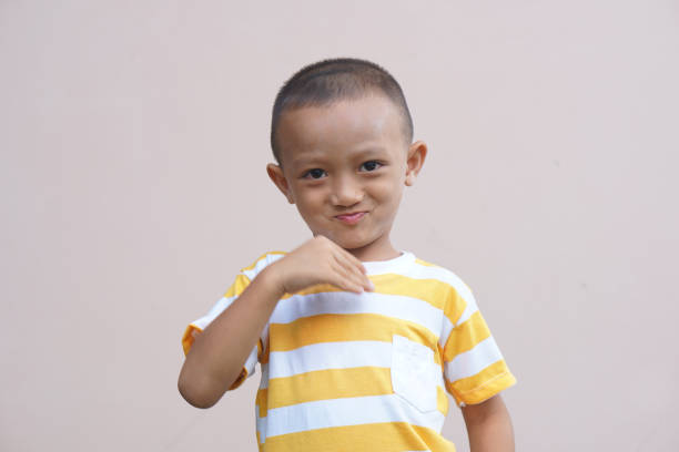 istock Asian boy smiling happily, cream background 1559569252