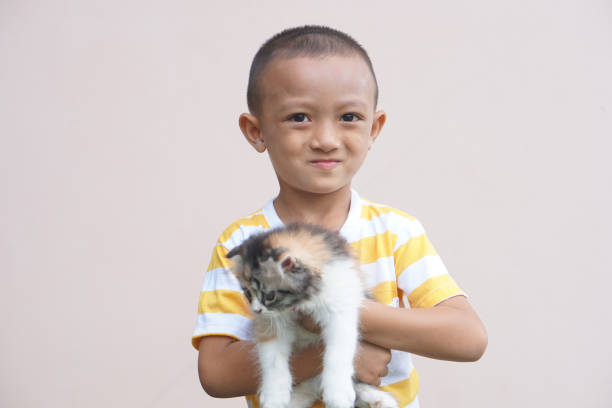 Asian boy smiling happily with his pet cat