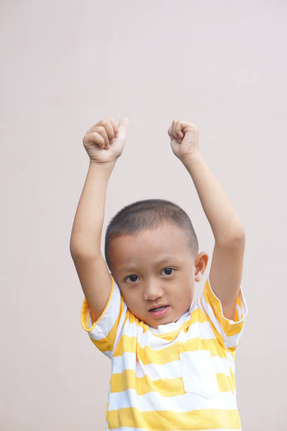 istock Asian boy smiling happily, cream background 1559569780