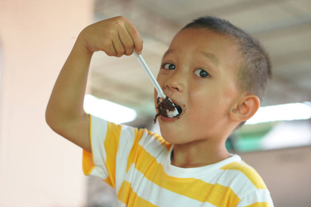 istock boy eating chocolate cake smeared mouth 1559577950