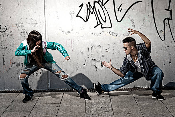 Young couple dancers hip hop dancing fight acting urban scene stock photo