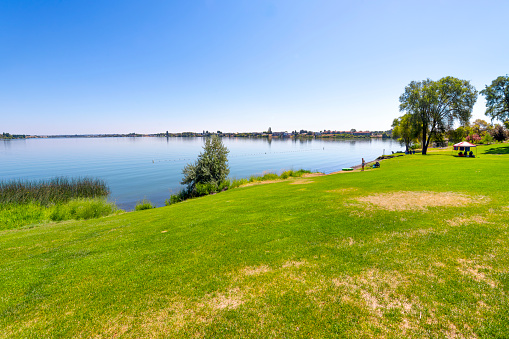 A summer day at the 24 acre lakeside Blue Heron Park in the city of Moses Lake, Washington, in Central Washington, USA. The waterfront public park includes picnic space, shoreline beach access, boat launch, fishing bridge, swim area and wetlands for wildlife viewing as well as a small 9 hole golf course. Moses Lake is a city in Grant County, Washington, United States.