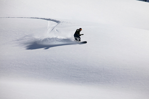 Snow boarder in fresh powder snow, New Zealand