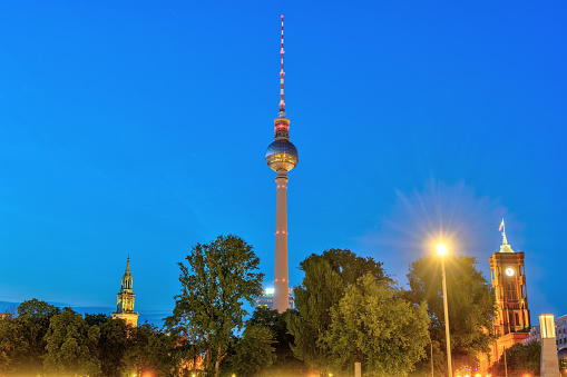 The famous Television Tower with the towers of the Marienkirche and the town hall in Berlin at night