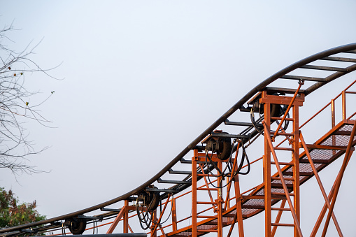 Steel track structure of roller coaster ride in amusement park on sky background.