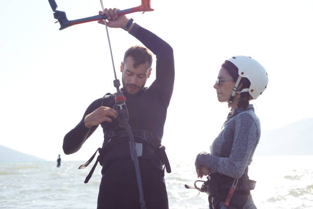 istock Young instructor preparing a woman for kiteboarding on the beach 1559666725