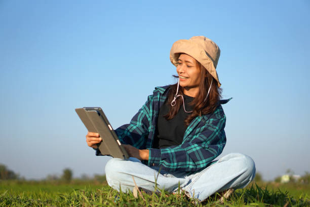 istock Asian female farmer delighted with rice growth target. Computer analysis 1559694497