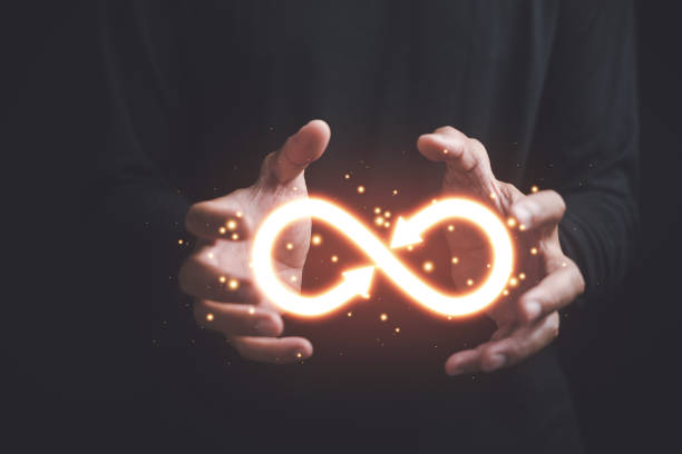 istock Circular infinity symbol in businessman's hand on dark background 1559697892