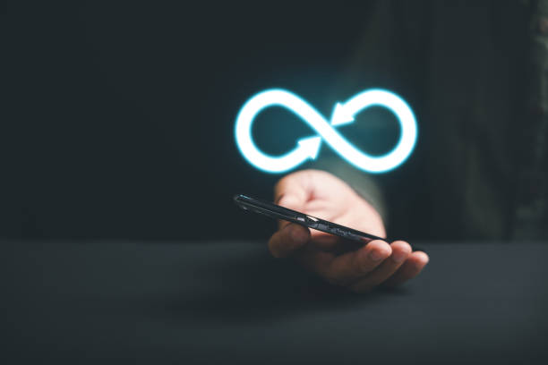 istock Businessman presents smartphone with infinity symbol 1559697905