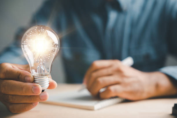 istock Businessman records a good idea, holding a light bulb 1559697914