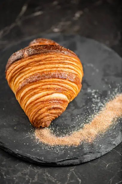 Close-up of crispy, flaky, and delicious butter croissant coated in cinnamon sugar.