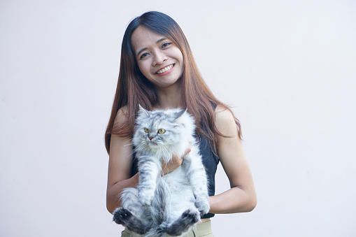 Woman smiling happily holding a gray cat