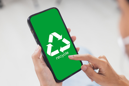 Female hands holding smartphone with recycle symbol eco environment Icon. Network connection recycling concept. waste sorting that can be recycled.