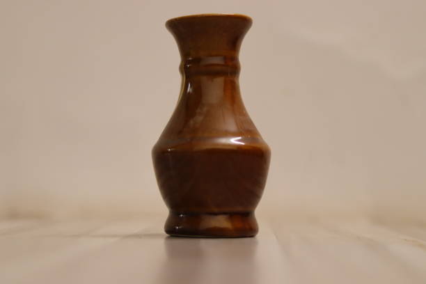 istock A plain brown antique and shiny vase in a white background 1559706577