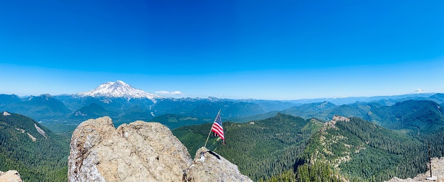 The American flag on a rocky outcropping surrounded by majestic mountain peaks