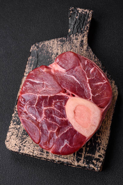 istock Fresh raw beef steak with bone or ossobuco with salt, spices and herbs 1559782489