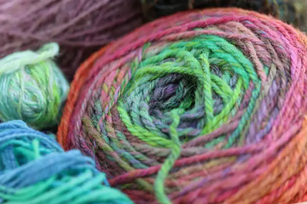 Beautiful balls of handspun yarn wool of a colourful skein of organic natural handspun and handdyed merino sheep wool, silk, linnen mix yarn fleece, spun on a traditional spinning wheel.