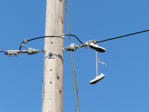 Sneakers Hanging from Power Lines. Concept: Secret Message, shoefiti or shoe tossing