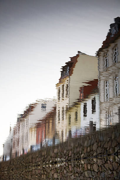 This upright photo shows the reflektion of houses on the water in the centr of Wismar in Mecklenburg West Pomerania. The photo is turned upside down to cause a beautiful irritation.