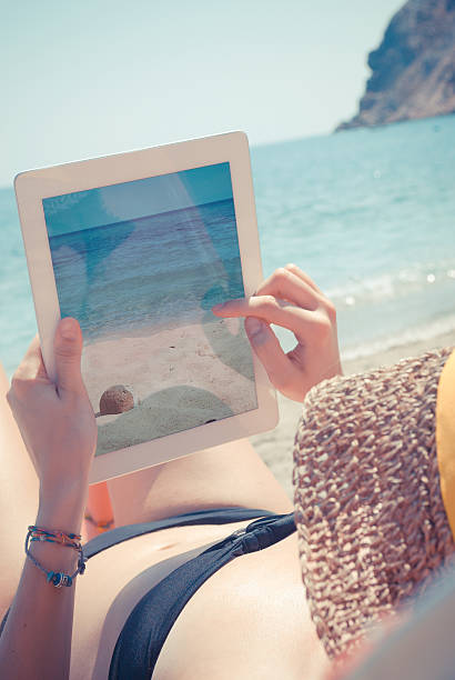istock A woman taking a picture of the beach using a tablet 155983768