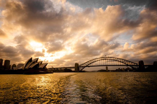 panoramablick auf das opernhaus und die harbour bridge bei sonnenuntergang - sydney harbor australia financial district cruise ship stock-fotos und bilder